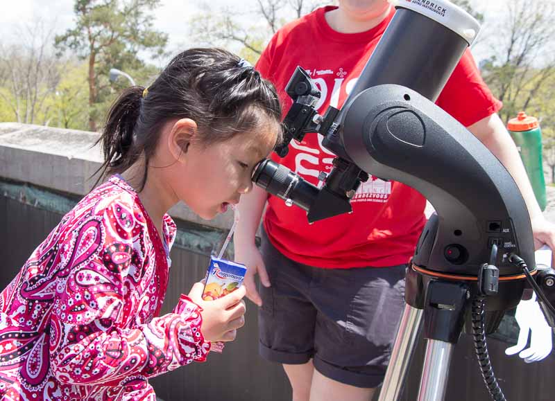 Girl looking into telescope
